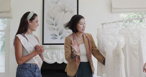 Bride-to-be Discussing Wedding Dress with Designer in Elegant Boutique
