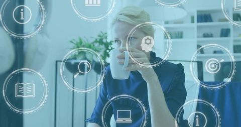 Mature professional woman drinking coffee while browsing digital business interface overlay