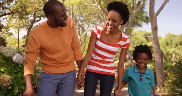 Happy Family Walking Down Sunlit Path in Park - Download Free Stock Images Pikwizard.com