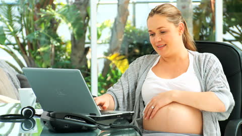 Expecting Woman Smiling While Working Remote from Home