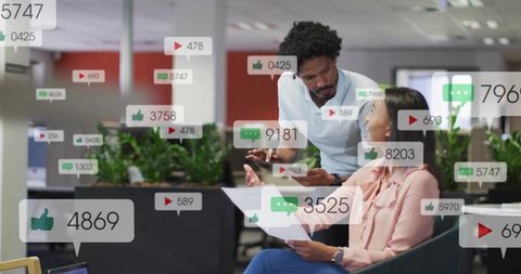 Colleagues analyzing social media metrics in modern corporate lounge