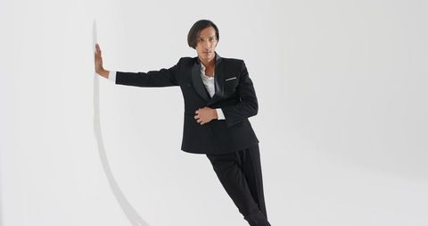 Contemporary Elegance Asian Male Model in Black Suit Leaning Gracefully
