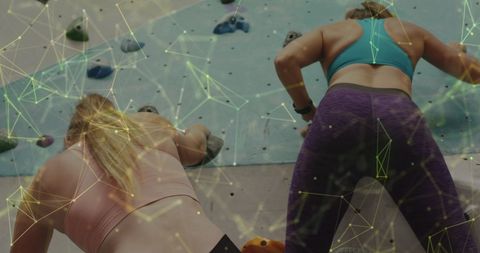 Women Climbing Indoor Rock Wall with Abstract Data Projection
