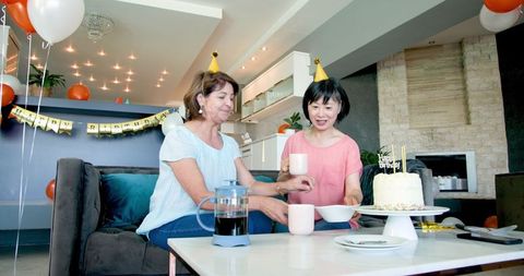 Senior Friends Celebrating Birthday with Coffee and Cake in Living Room