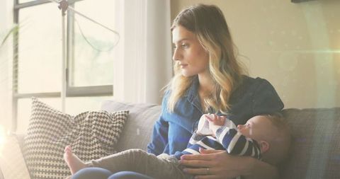 Mother Cradling Infant in Cozy Home Setting