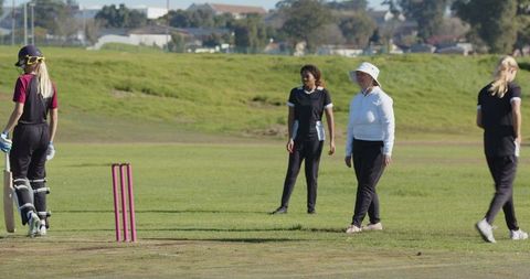 Women Engaging in Cricket Match Displaying Teamwork