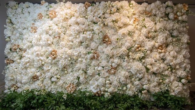 Ivory rose and peony floral backdrop wall with lush greenery for wedding and event decor