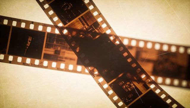 Overlapping 35mm film negatives with warm sepia backlight and grainy vintage perforations