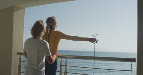 Couple Enjoying Scenic Ocean Balcony View During Vacation
