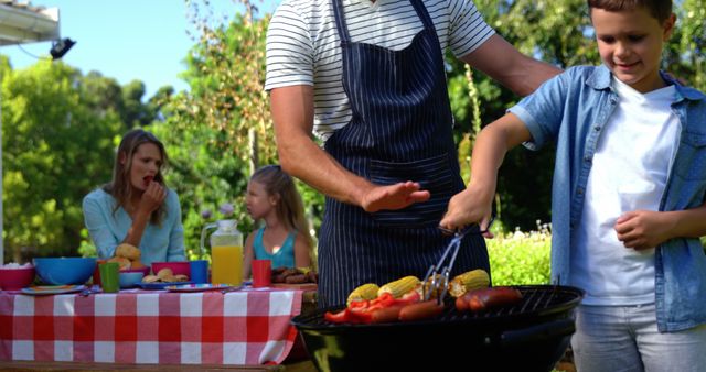 Father and Son Grilling at Outdoor Family Barbecue - Download Free Stock Images Pikwizard.com