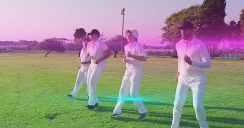 Cricket team jogging at sunrise warming up on grassy field with lens flare