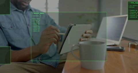 Denim-Shirted Man Using Tablet with Stylus in Home Office Showing Cybersecurity Interface