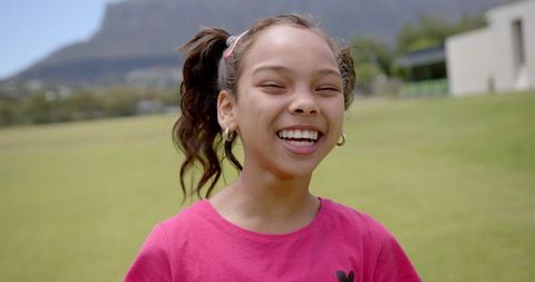 Joyful Girl Laughing Outdoors in Sunny Park