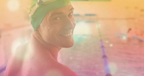 Smiling Swimmer Wearing Green Cap Looking Back by Poolside