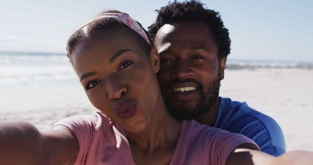Couple taking selfie on beach during sunny summer day. Ideal for promoting vacation deals, travel blogs, social media content, relationship tips, and outdoor activities.