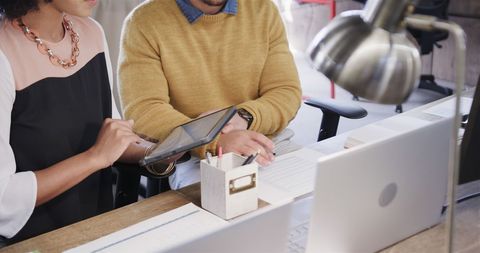 Colleagues collaborating with digital tablet in office