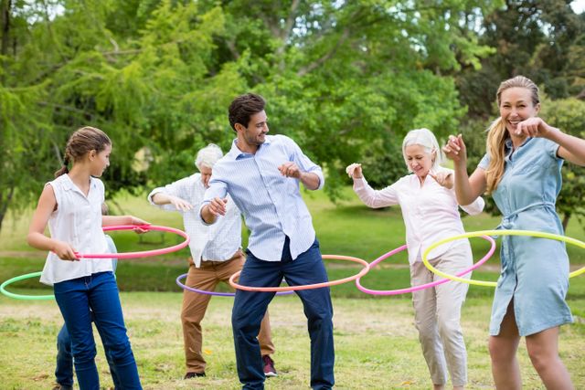 Multi-generation family playing with hula hoop in park