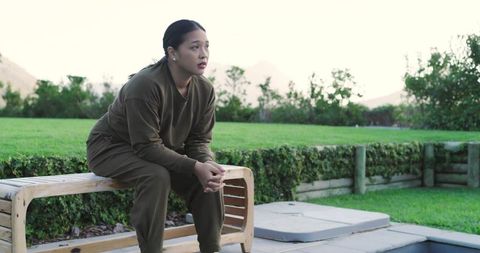 Woman reflecting by pool in tranquil garden setting