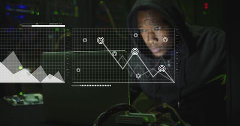 Hooded Hacker Analyzing Financial Charts in Server Room - Download Free Stock Images Pikwizard.com