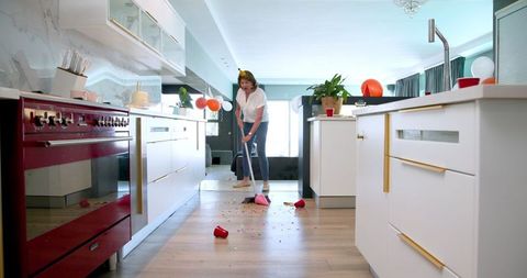 Senior Women Cleaning Post-party Mess in Kitchen