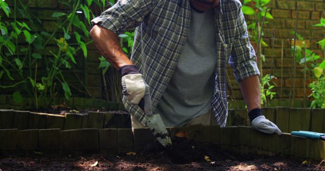 Mid-section of senior man digging in the soil with shovel