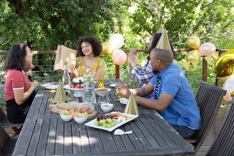 Friends Celebrating Birthday Gathering Outdoors with Gift Opening