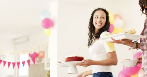 Cheerful Woman Holding Cake at Festive Celebration with Colorful Balloons