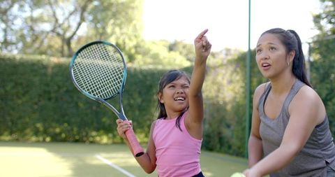 Mother and Daughter Playing Tennis, Building Bond Through Sport