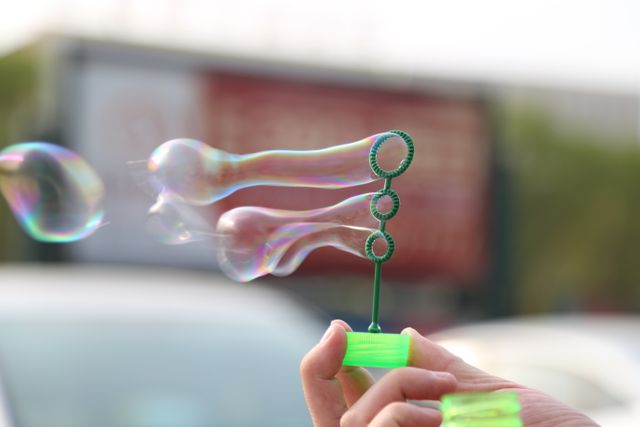 Hand Blowing Soap Bubbles with Green Bubble Wand Outdoors - Download Free Stock Photos Pikwizard.com
