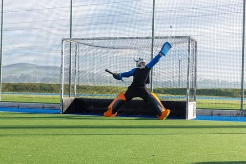 Goalkeeper blocking shot in exciting field hockey match