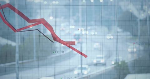 Descending red market graph over blurred urban traffic grid conveying economic downturn