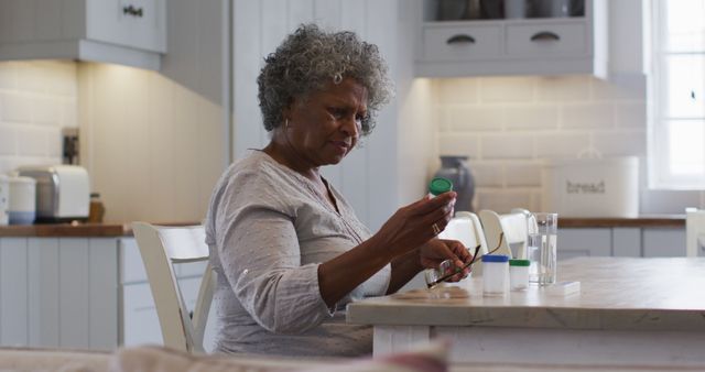 Senior Woman Taking Medication at Home in Kitchen - Download Free Stock Images Pikwizard.com