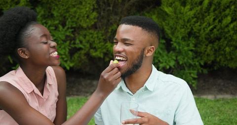 Happy Young Couple Enjoying Drink and Conversation Outside