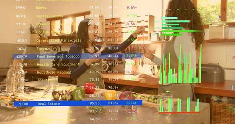 Two women cooking together with augmented reality stock market overlay in sunlit kitchen