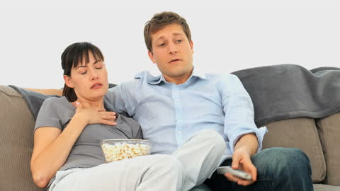 Couple Watching Scary Movie on Cozy Couch with Popcorn