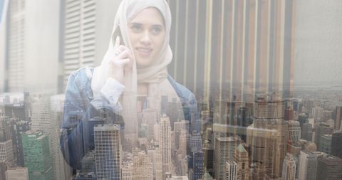 Young woman in hijab communicating over city skyline