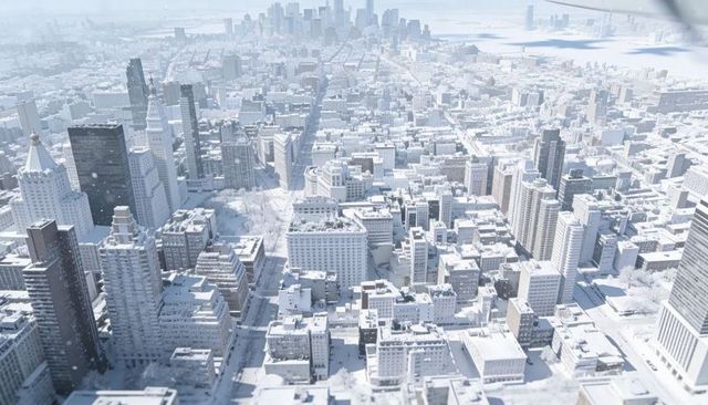 Surveying snow-covered downtown skyline from drone showing high-rise rooftops and harbor