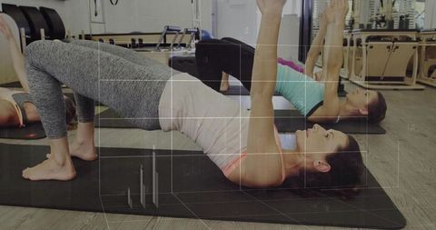 Women Practicing Glute Bridges in Modern Pilates Class