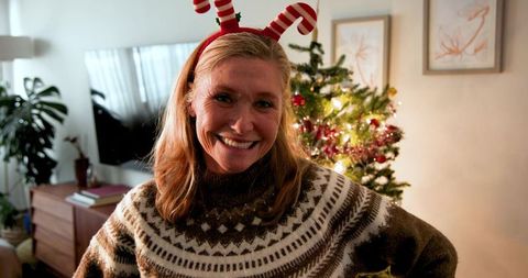 Middle-aged Woman Celebrating Christmas at Home with Festive Sweater