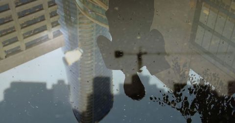 Puddle reflection showcasing urban architecture and nature
