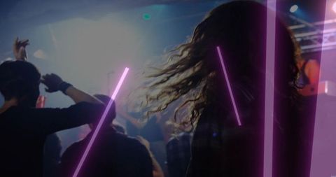 Long-haired concertgoer dancing toward stage holding red cup, neon magenta crowd haze