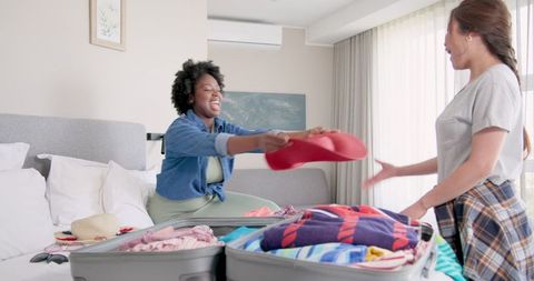 Happy lgbtq couple packing for vacation at home