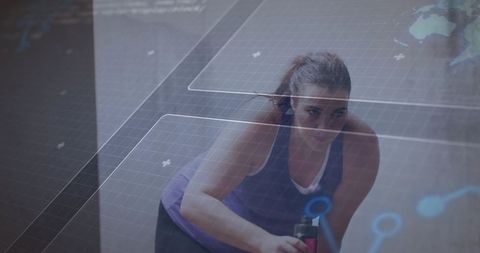 Determined woman training with water bottle in futuristic gym hud overlay fitness tracking