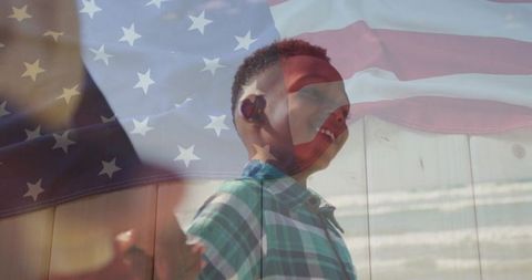 Smiling boy beside american flag celebrating heritage outdoors