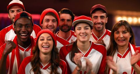 Diverse Group of Enthusiastic Sports Fans Celebrating Victory Indoors
