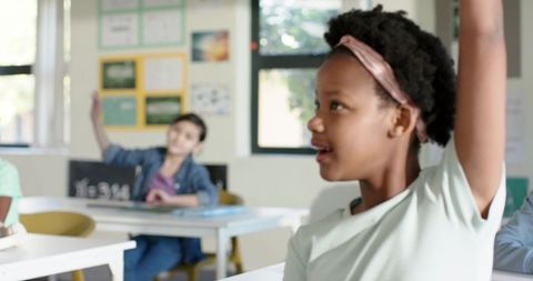 African American girl raising hand in classroom engaging in active learning