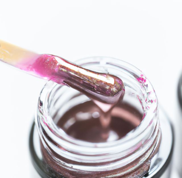 Close up of pink lip gloss in jar on white background. Fashion, glamour and beauty products.