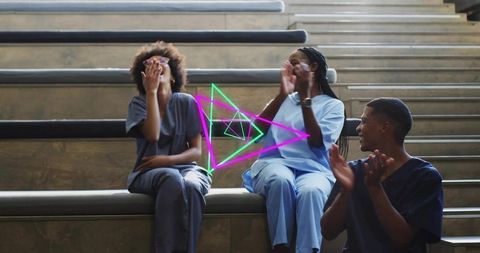 Laughing healthcare team in scrubs celebrating on tiered steps with neon hologram