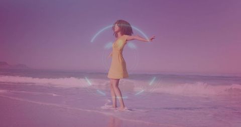 Young woman balancing on shoreline wearing yellow dress with holographic light halo glow