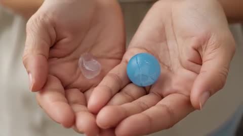 Hands Comparing Blue Hydrogel Bead and Clear Gel Pellet Close-Up Video